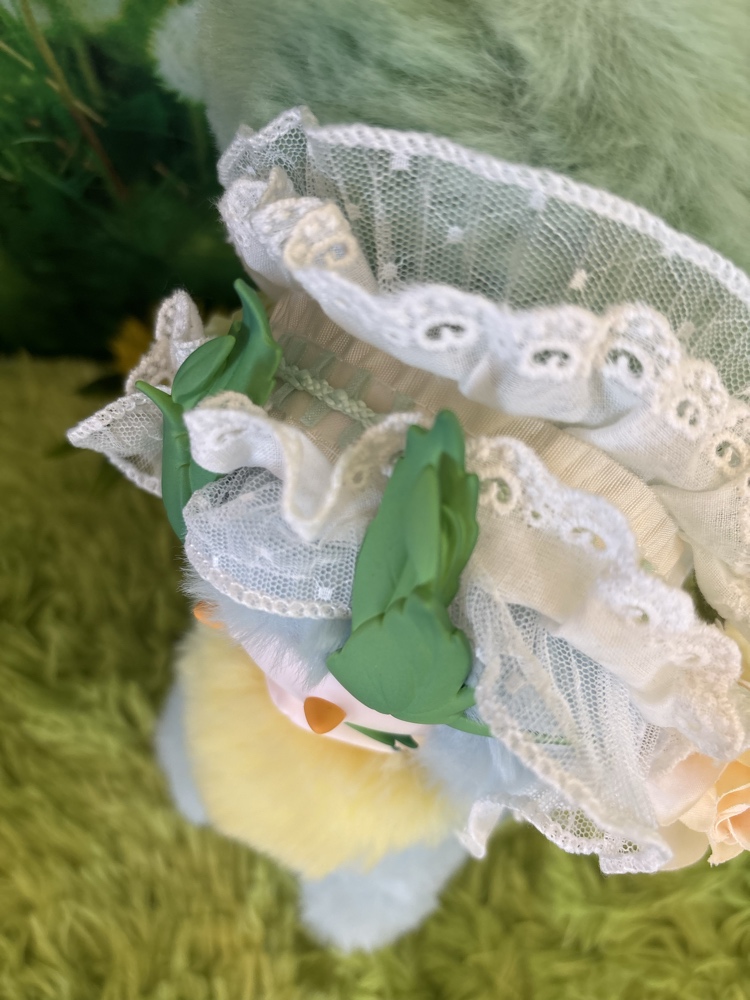 Top down close up of the Tutulong Herbalist plush showcasing the layered white lace ruffles and green leaf antlers.